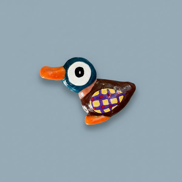 Colorful duck-shaped object on a textured gray surface